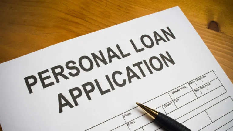 Personal loan application form on a wooden table with a pen