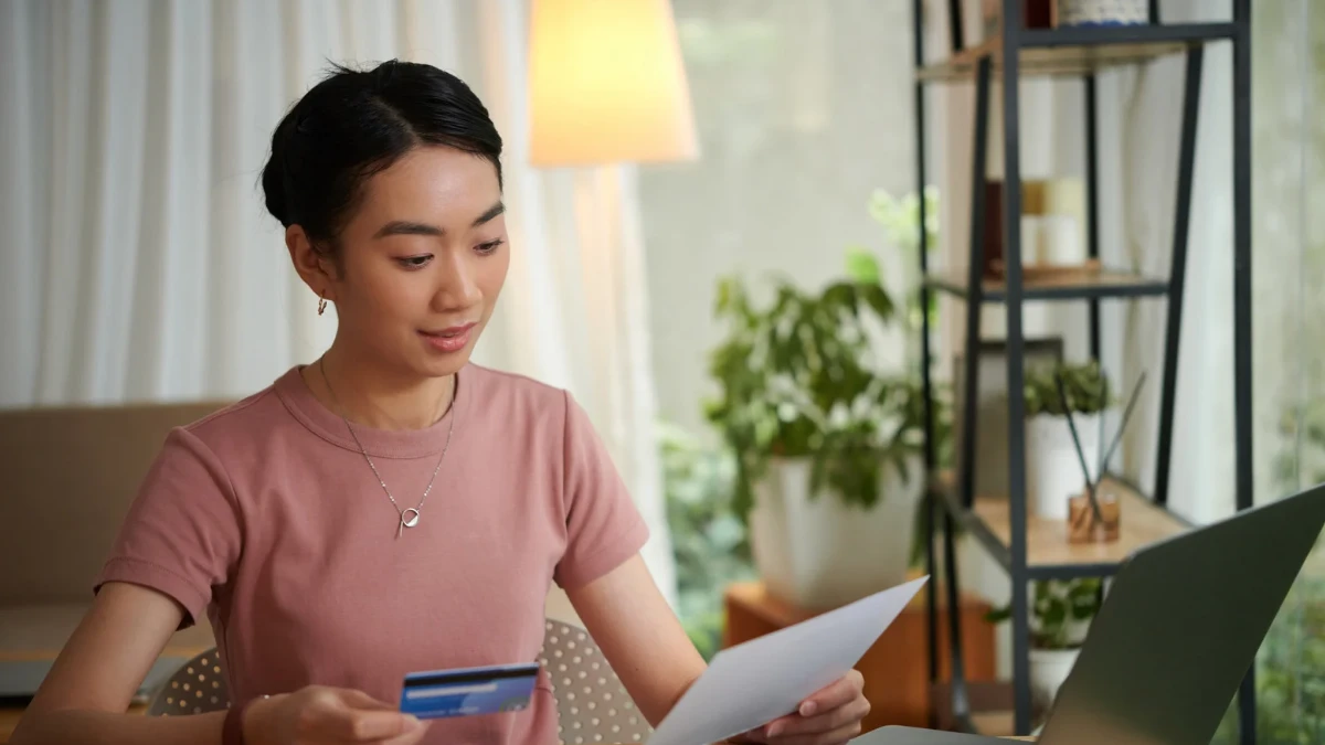 Woman reviewing bank statement and credit card letter to understand bank fees and charges