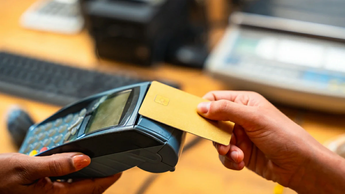 Customer paying with a credit card at a modern POS terminal, showcasing digital payment technology in a retail store.
