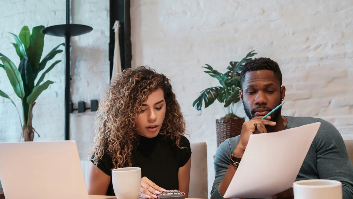 Young couple reviewing and planning their monthly budget at home, managing finances and expenses.