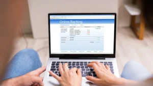 Couple reviewing their joint bank account online on a laptop, checking transactions and managing finances together.