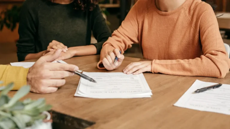 Hand writing financial plans on paper, illustrating short-term and long-term investments and goal planning for smart money decisions.