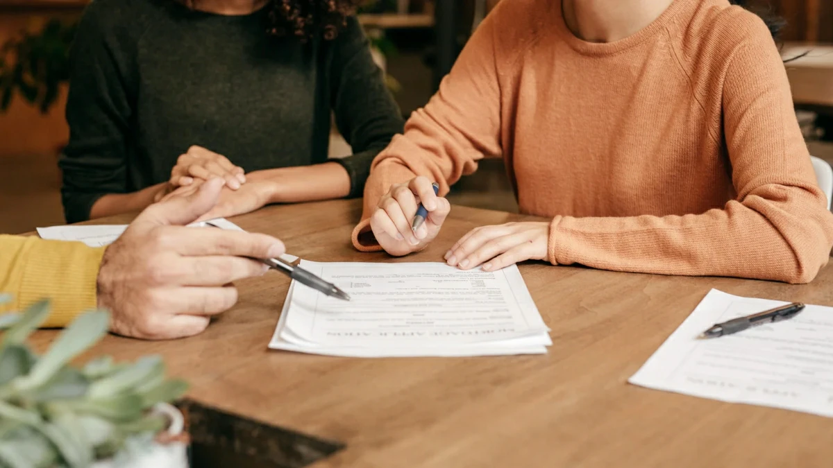 Hand writing financial plans on paper, illustrating short-term and long-term investments and goal planning for smart money decisions.